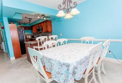 a dining room and kitchen with a table and chairs at Regency 1023 in Panama City Beach