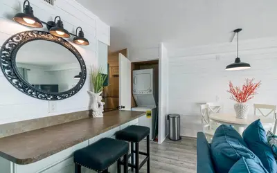 a living room with a mirror and a table at Summit 811 in Panama City Beach