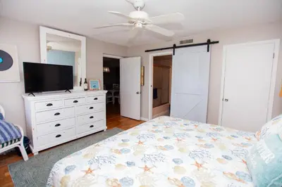 a bedroom with a bed and a flat screen tv at Moonspinner 808B in Panama City Beach