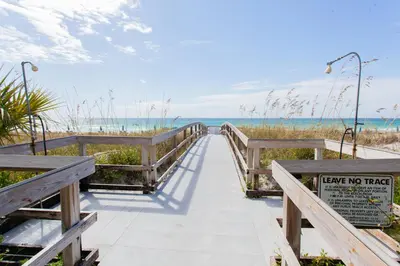 a boardwalk to the beach with a sign that says leave no trace at Moonspinner 808B in Panama City Beach