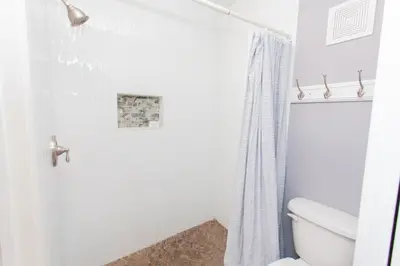 a bathroom with a shower curtain and a toilet at Summit 627 in Panama City Beach