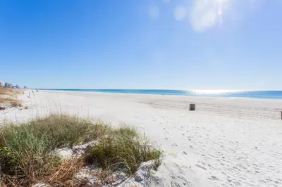 a sandy beach with a trash can on it at Summit 627 in Panama City Beach