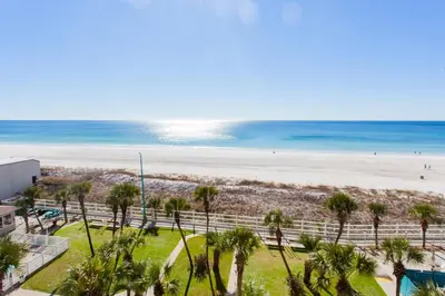 a view of a beach with palm trees and the ocean at Summit 627 in Panama City Beach