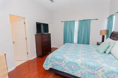 a bedroom with a bed and a dresser and a television at Palms A4 Main in Panama City Beach