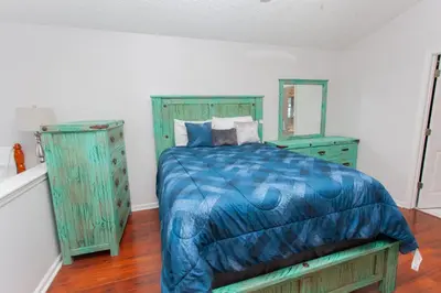a bedroom with a bed with a blue comforter at Palms A4 Main in Panama City Beach