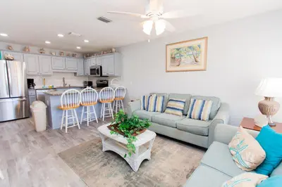 a living room with a couch and a kitchen at Horizon South 58-203 in Panama City Beach