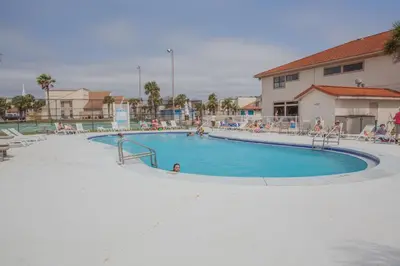 a large swimming pool with people sitting around it at Horizon South 58-203 in Panama City Beach