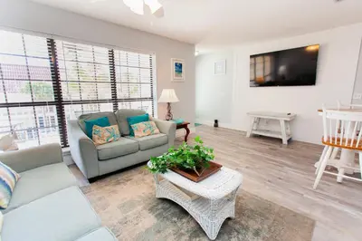 a living room with a couch and a tv at Horizon South 58-203 in Panama City Beach
