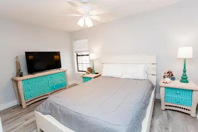 a bedroom with a bed and a flat screen tv at Horizon South 58-203 in Panama City Beach