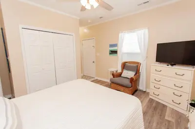 a bedroom with a bed and a tv and a chair at 125 E Lakeshore DR in Panama City Beach
