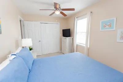 a bedroom with a blue bed and a ceiling fan at 125 E Lakeshore DR in Panama City Beach