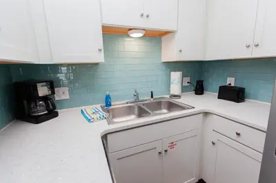 a kitchen with white cabinets and a sink at Summit 203 in Panama City Beach