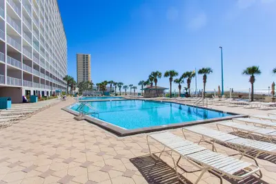 a swimming pool with lounge chairs next to a building at Summit 203 in Panama City Beach