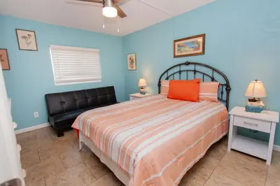 a bedroom with a bed and a black leather chair at Sugar Beach E2 in Panama City Beach