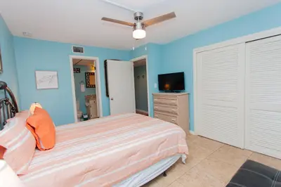 a bedroom with a bed and a flat screen tv at Sugar Beach E2 in Panama City Beach