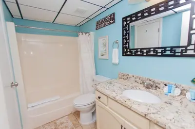 a bathroom with a sink and a toilet and a mirror at Sugar Beach E2 in Panama City Beach