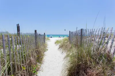 a path leading to a beach with a fence at Sugar Beach E2 in Panama City Beach