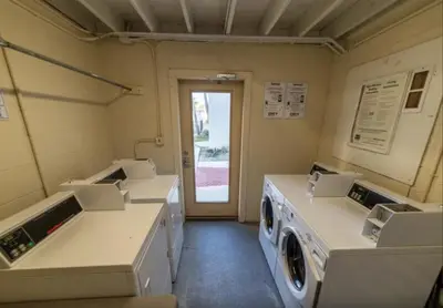 a laundry room with three washing machines and a door at Sugar Beach E2 in Panama City Beach