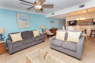 a living room with two couches and a kitchen at Sugar Beach E2 in Panama City Beach