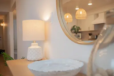 a lamp and a bowl on a table with a mirror at Regency 501 in Panama City Beach