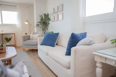 a living room with a white couch and blue pillows at Regency 501 in Panama City Beach