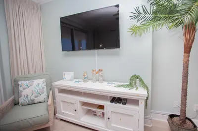 a white vanity with a chair and a palm tree at Ocean Ritz 1501 in Panama City Beach