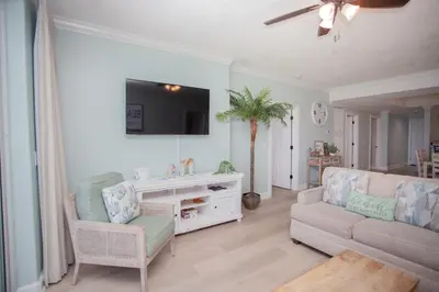 a living room with a couch and a tv at Ocean Ritz 1501 in Panama City Beach