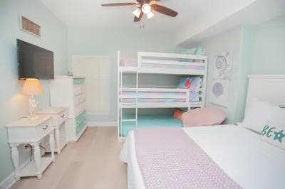 a bedroom with a bed and a dresser and a desk at Ocean Ritz 1501 in Panama City Beach
