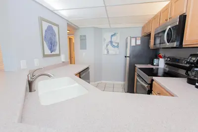 a kitchen with a sink and a refrigerator at Summerhouse 1005a in Panama City Beach
