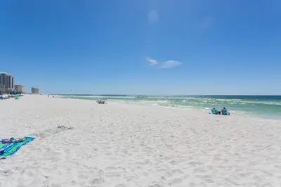 a beach with a kite flying over the ocean at Summerhouse 1005a in Panama City Beach