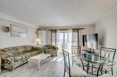 a living room with a couch and a glass table at Walk to Pools and Outdoor Bar! Oceanfront PCB Gem in Panama City Beach