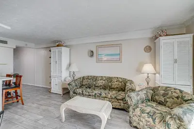 a living room with a couch and a chair at Walk to Pools and Outdoor Bar! Oceanfront PCB Gem in Panama City Beach