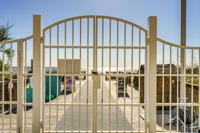 an open gate with a beach behind it at Walk to Pools and Outdoor Bar! Oceanfront PCB Gem in Panama City Beach