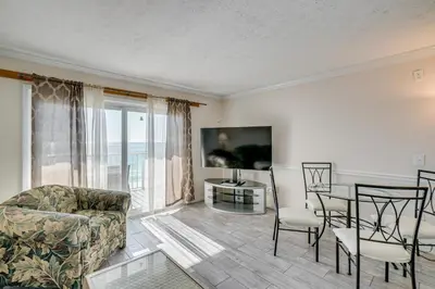 a living room with a couch and a table and chairs at Walk to Pools and Outdoor Bar! Oceanfront PCB Gem in Panama City Beach