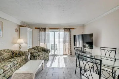 a living room with a couch and a table at Walk to Pools and Outdoor Bar! Oceanfront PCB Gem in Panama City Beach