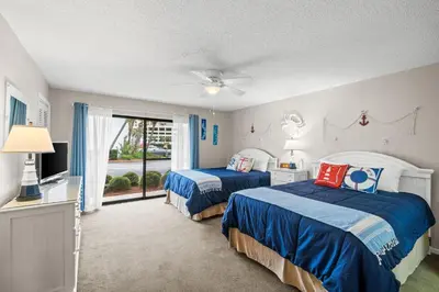 a bedroom with two beds and a window at Edgewater Golf Villas #3105 by Book That Condo in Panama City Beach