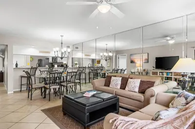 a living room with couches and a dining room and kitchen at Edgewater Golf Villas #3105 by Book That Condo in Panama City Beach