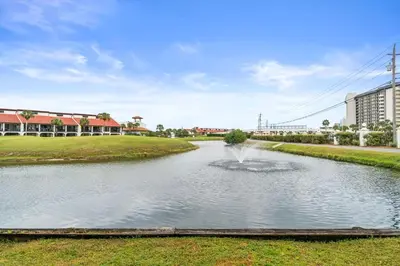 a pond with a fountain in the middle of a park at Edgewater Golf Villas #3105 by Book That Condo in Panama City Beach