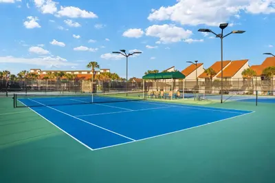 a tennis court with buildings in the background at Edgewater Golf Villas #3105 by Book That Condo in Panama City Beach