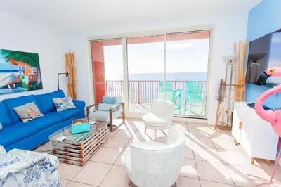a living room with a blue couch and views of the ocean at Shores of Panama 2220 in Panama City Beach