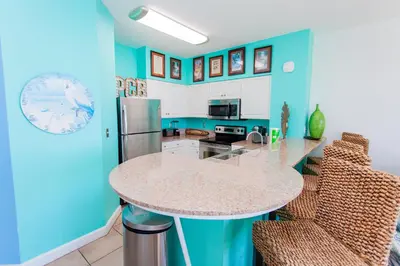 a kitchen with blue walls and a counter top at Shores of Panama 2220 in Panama City Beach