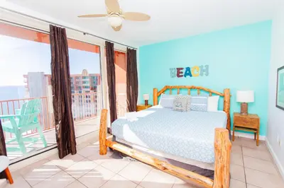a bedroom with a bed and a balcony at Shores of Panama 2220 in Panama City Beach