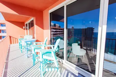 a balcony with blue chairs and tables on a building at Shores of Panama 2220 in Panama City Beach
