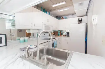 a kitchen with white cabinets and a sink at Mariner West 508 in Panama City Beach