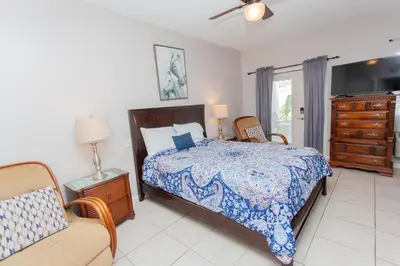 a bedroom with a bed and a chair and a dresser at Palms A4 Studio in Panama City Beach