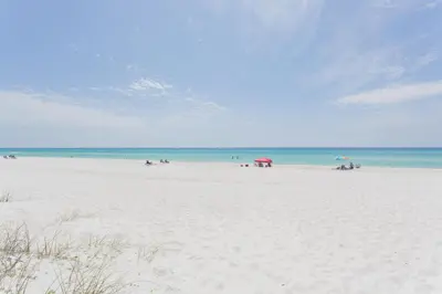 a group of people on a beach with the ocean at Palms A4 Studio in Panama City Beach