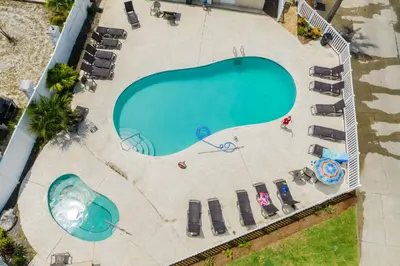 an overhead view of a swimming pool with chaise lounge chairs at Palms A4 Studio in Panama City Beach