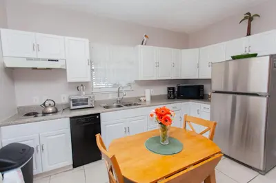 a kitchen with a table with a vase of flowers on it at Palms A4 Studio in Panama City Beach