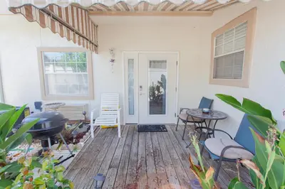 a patio with chairs and a table and a grill at Palms A4 Studio in Panama City Beach