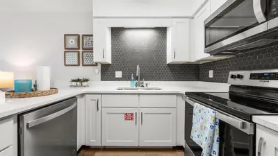 a kitchen with white cabinets and a sink at West End Coastal Escape Renovated 1BR Condo w Pool Beach Access 72 in Panama City Beach